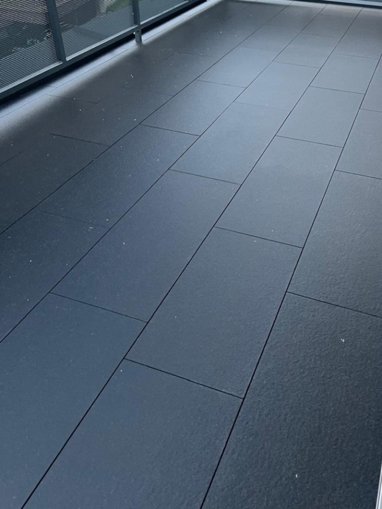 Graue Feinsteinzeugplatten im Außenbereich nach der Reinigung
